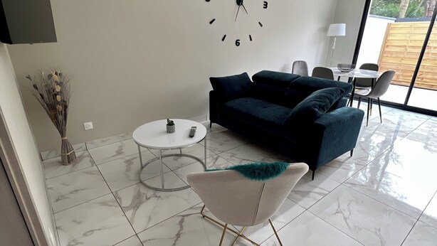 A modern living room with a sofa, a coffee table, and a clock on the wall. - House in Creteil near Paris (creteil)