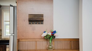 A wooden cabinet with a vase of flowers on top. - Cozy 2BR Quincy Hideout • Pet-Friendly • Wollaston Beach & Red Line 74L (Quincy)