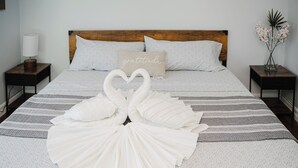 A neatly made bed with a heart-shaped pillow arrangement and a decorative pillow with the word "gratitude". - Cozy 2BR Quincy Hideout • Pet-Friendly • Wollaston Beach & Red Line 74L (Quincy)