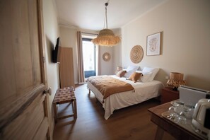 Une chambre à coucher avec un lit, une table de chevet et un luminaire suspendu.