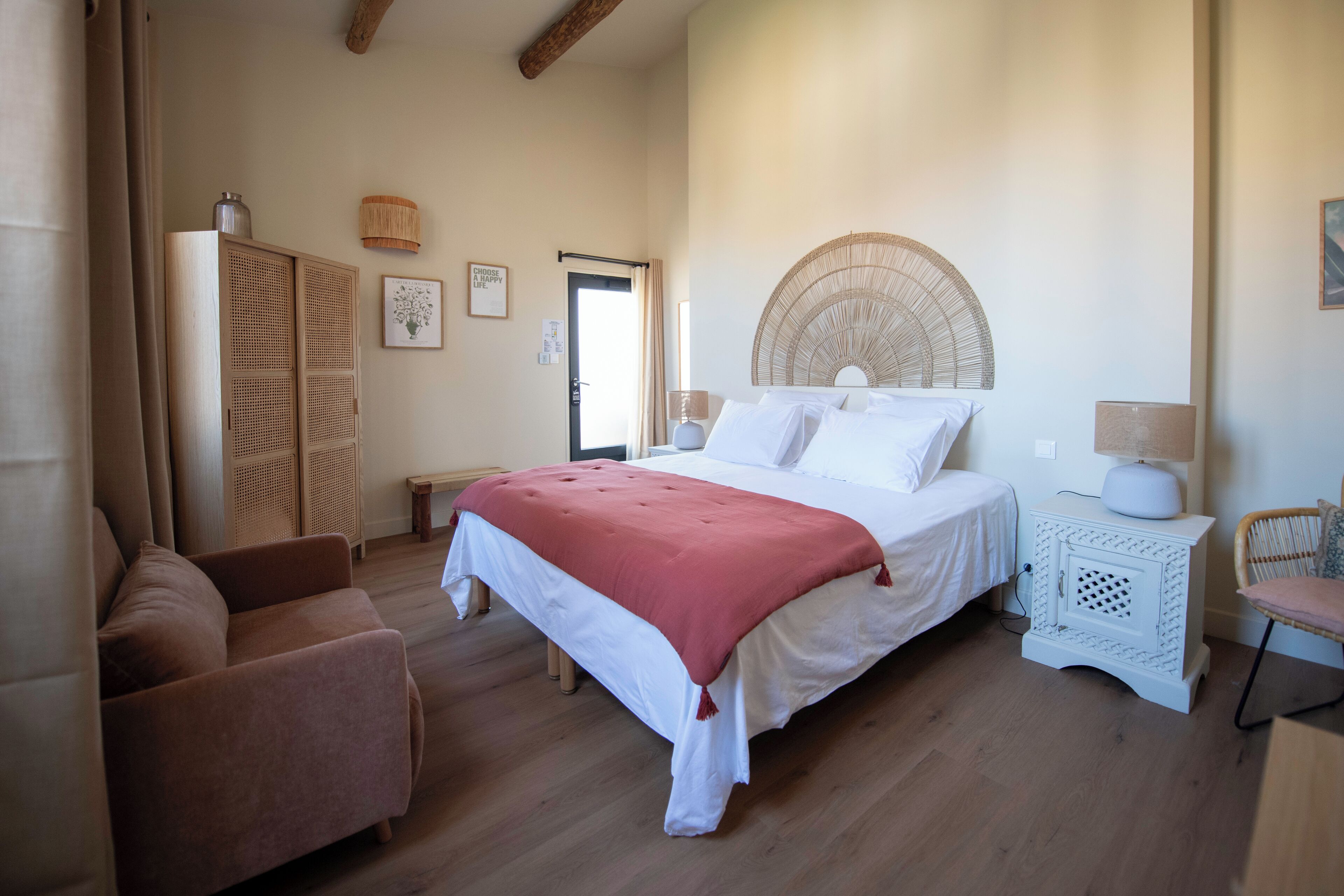Un dormitorio con cama, sofá, mesita de noche y silla.