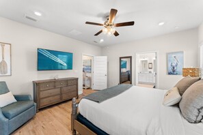 A bedroom with a bed, a dresser, a chair, and artwork on the walls. - Pet Friendly Beach House – Osprey Landing (Port St. Joe)