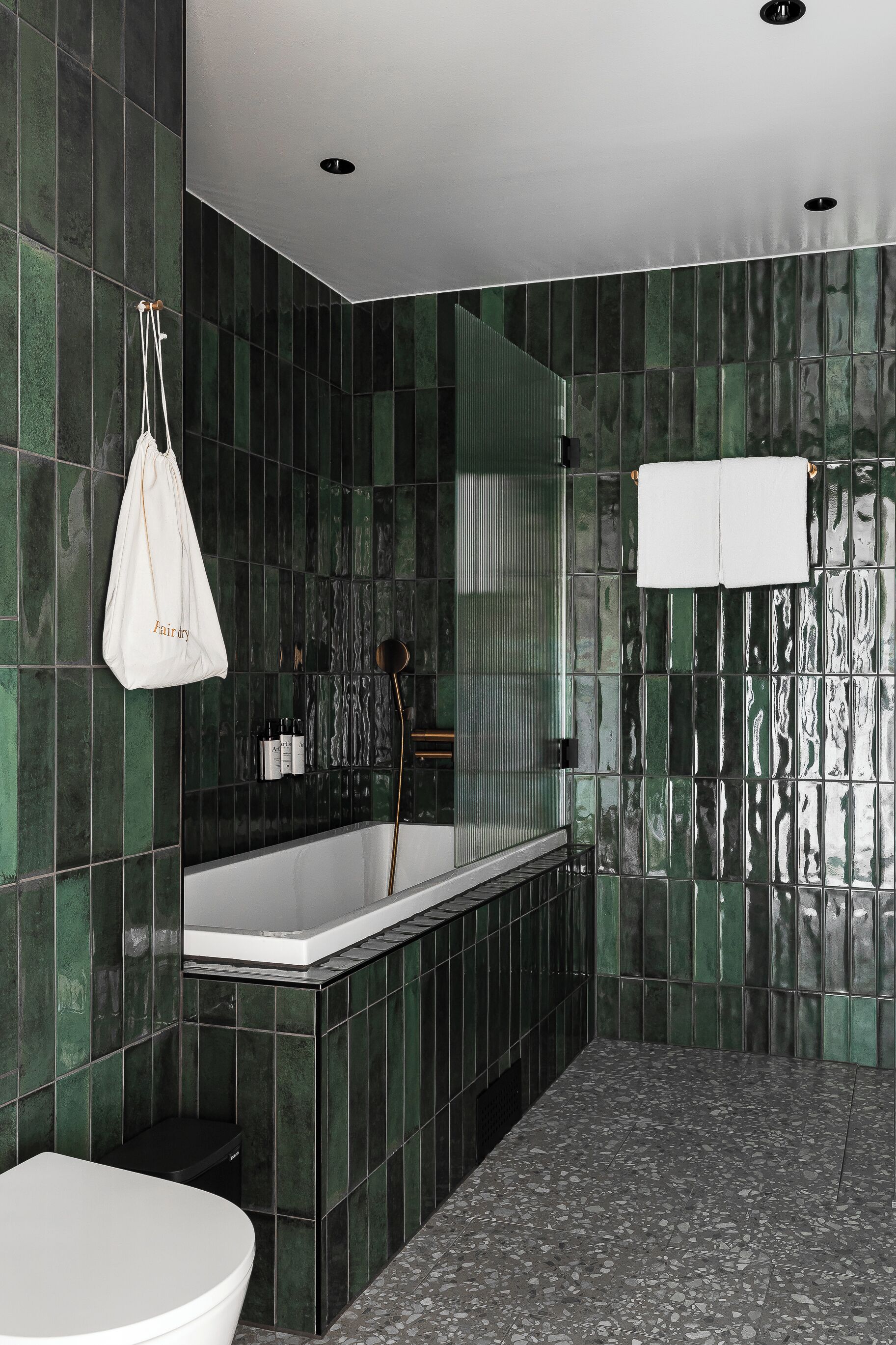 A modern bathroom with a freestanding bathtub, a toilet, and a shower area.