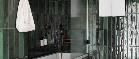 A modern bathroom with a freestanding bathtub, a toilet, and a shower area.