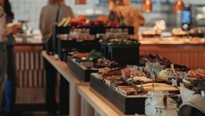 Un buffet proposant divers plats, avec une personne à l’arrière-plan.