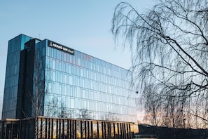 Hotel Hernö Gin features a sleek glass facade reflecting the surroundings.