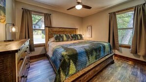 A bedroom with a wooden bed, a ceiling fan, and a dresser. - "Her Endless Views" cabin has incredible mountain views, hot tub, and firepit (Murphy)