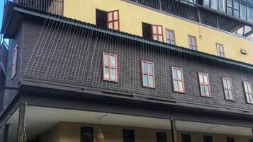 A multi-story building with a yellow facade and multiple windows.