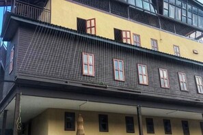 Ein mehrstöckiges Gebäude mit einer gelben Fassade und zahlreichen Fenstern.