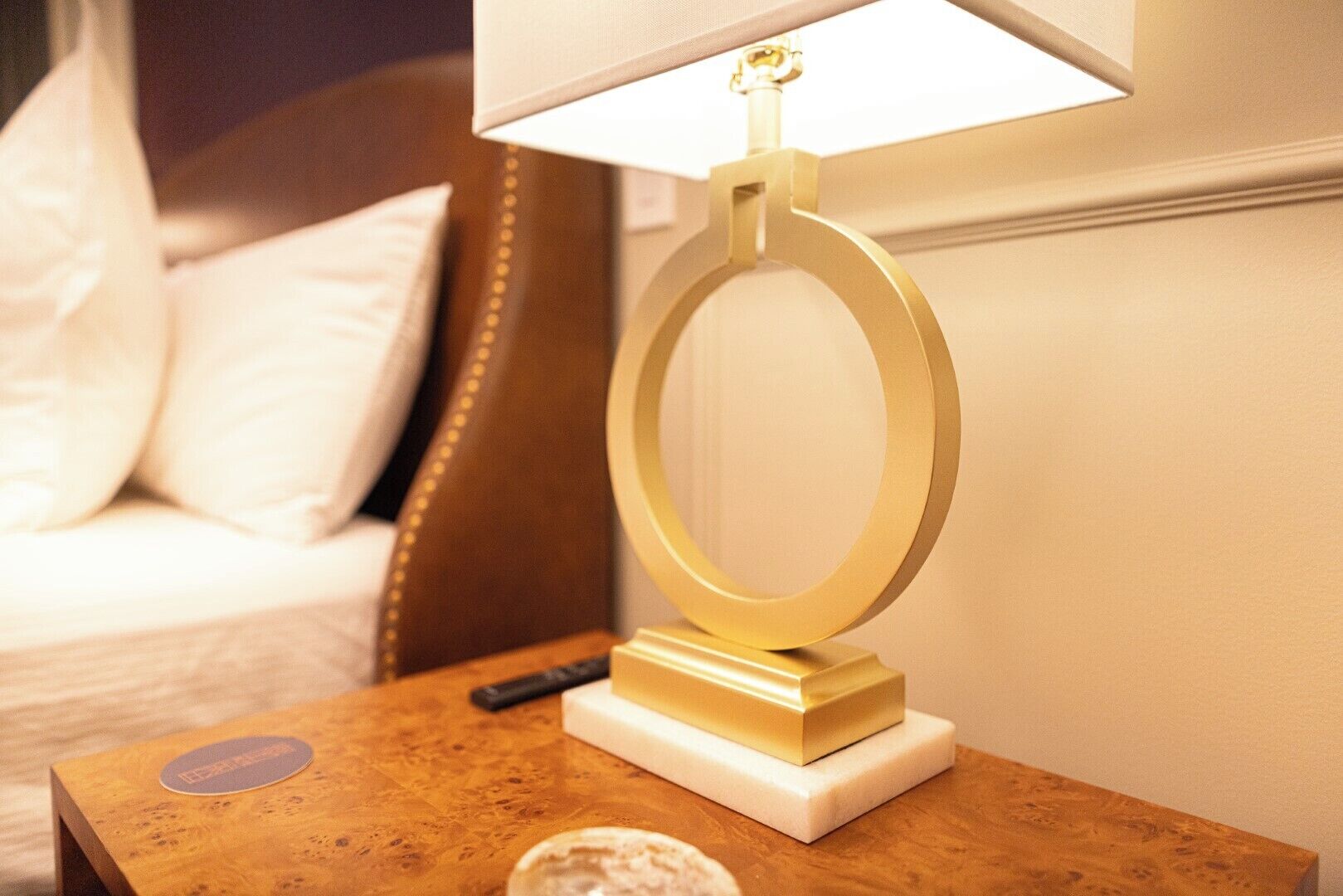 Ein Nachttisch mit Lampe, Fernbedienung und einer kleinen Dekoration.