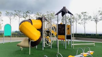 A playground with a slide, climbing structures, and swings.