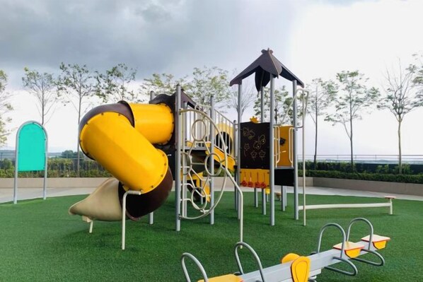 A playground with a slide, climbing structures, and swings.
