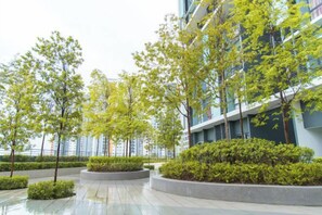 A modern building with a courtyard featuring trees and shrubs.