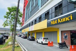 Un immeuble commercial doté d’une devanture portant le nom « Mat Kumci » et d’un parking où sont stationnées des voitures et une moto.