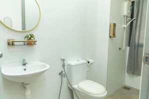 Une salle de bain avec un lavabo, des toilettes et une douche.