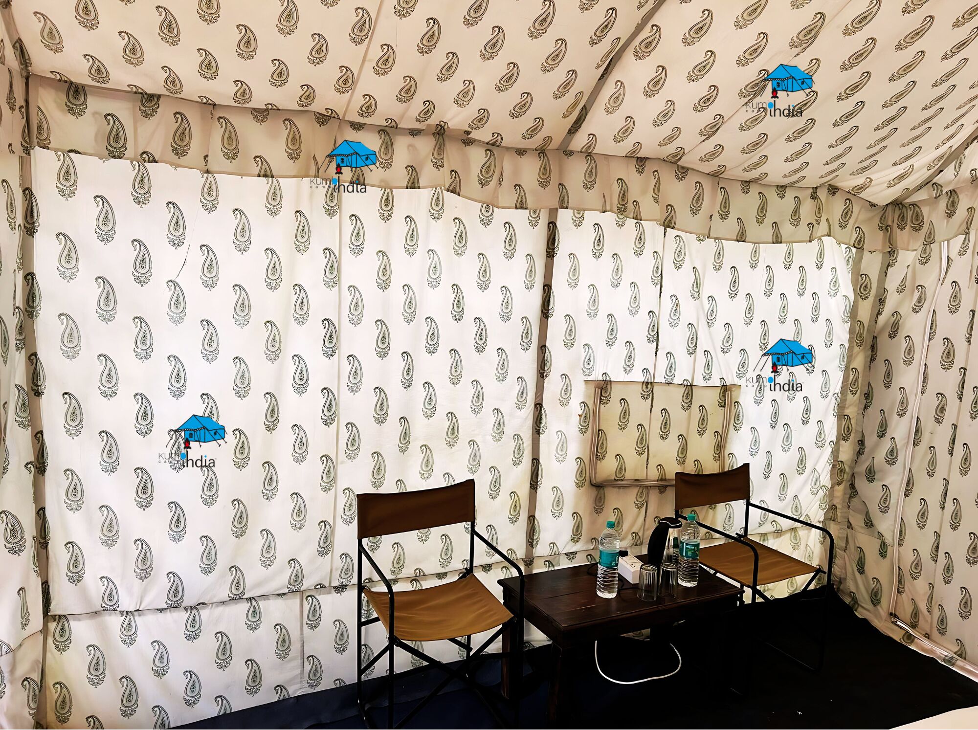 A room with a patterned wall, a wooden table with chairs, and a water bottle on the table.