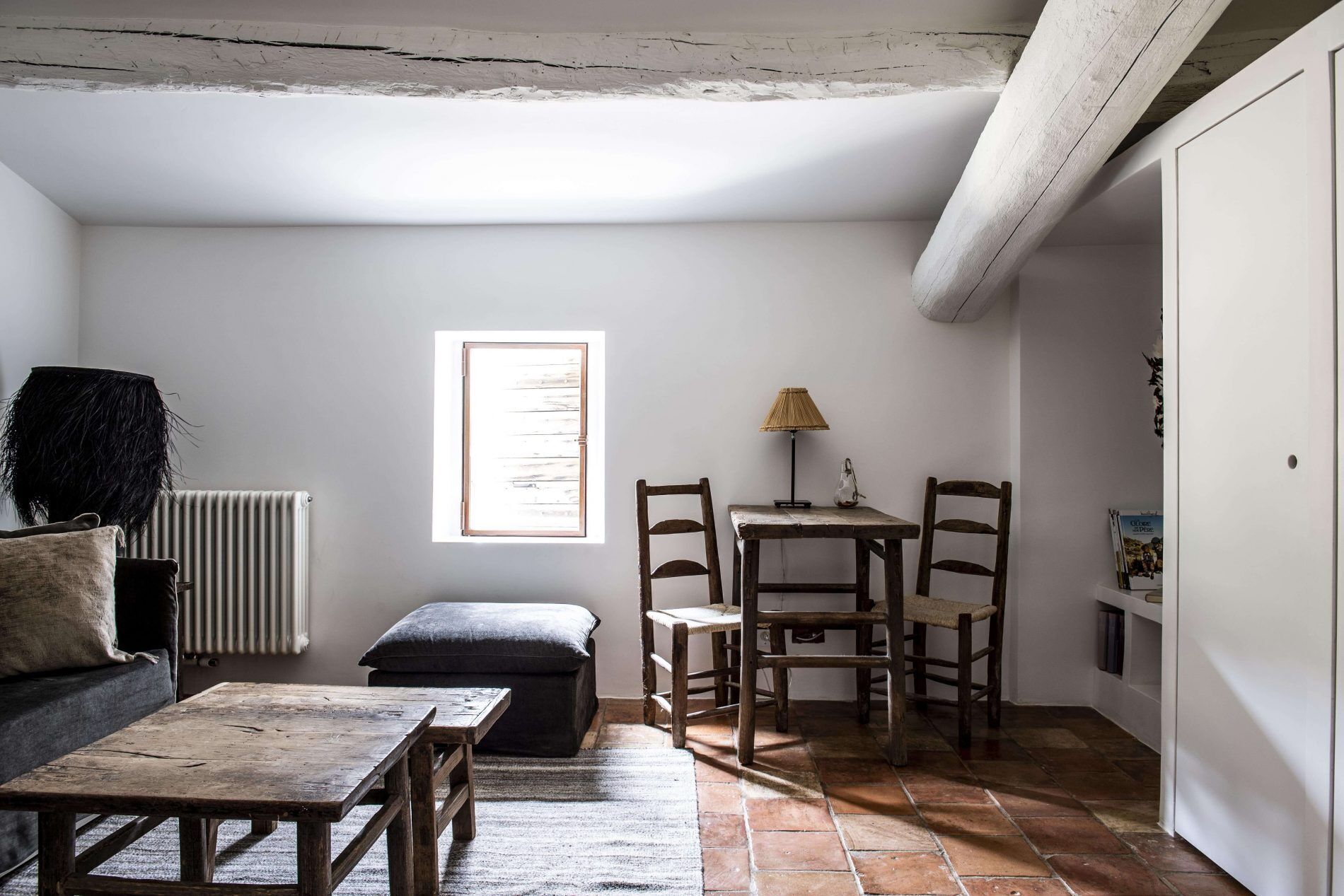 A cozy room with a rustic wooden table, a small window, and a radiator.
