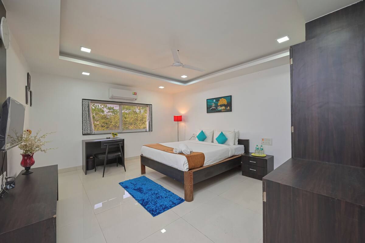 A bedroom with a bed, desk, and wardrobe.