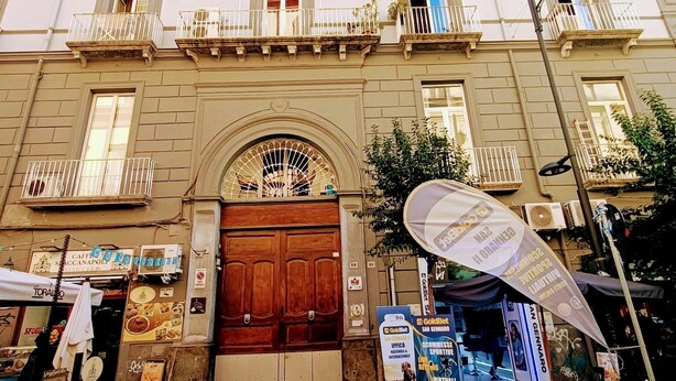 A historic building with a central entrance, large wooden doors, and multiple balconies. - La Maison di Partenope (Naples)