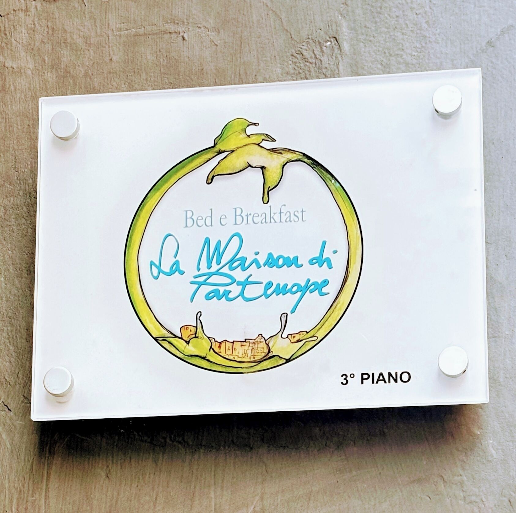Pyöreä kyltti, jossa on kuvattuna etana ja teksti: ”Bed & Breakfast La Maison di Fartengue” ja ”3. kerros”.