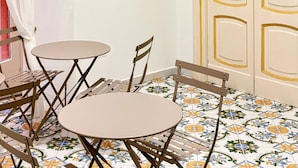 A room with a colorful mural, a door with a small sticker, and a tiled floor. - La Maison di Partenope (Naples)