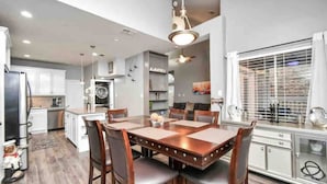 A modern kitchen with white cabinets, a dining table with chairs, and a built-in oven. - Beautiful 3-bedroom Patio Home in Houston w/ WiFi, AC near Champions Golf course (Houston)