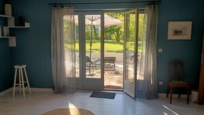 Een kamer met een grote schuifglazen deur die uitkomt op een terras.