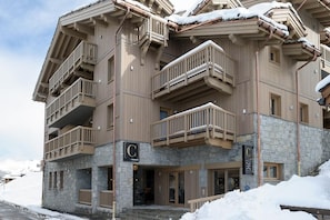 Un hôtel à plusieurs étages, doté de balcons, d’une façade en pierre et d’une enseigne arborant un logo en forme de « C ».