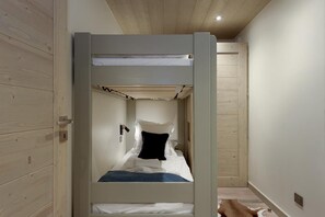 A bunk bed in a room with wooden walls and a ceiling.