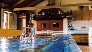 A rustic kitchen with wooden beams, a blue table, and a bottle of HIGHLAND BEER. - Apartments in Pula/istrien 11169 (Pula)