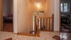 A staircase with wooden balusters, a small wall-mounted air conditioner, and a checkered floor pattern. - Apartments in Rovinj/istrien 11491 (Rovinj)