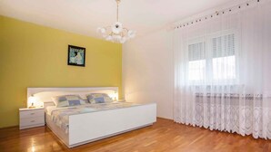 A bedroom with a bed, nightstands, a chandelier, and a window with curtains. - Apartments in Rovinj/istrien 11491 (Rovinj)