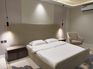 Et moderne hotelværelse med en stor seng, sengeborde, en stol og en aircondition.