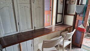 A kitchen with a wooden countertop, two wicker chairs, and a tiled floor. - Budget Adventurer's Hut (Bridgetown)