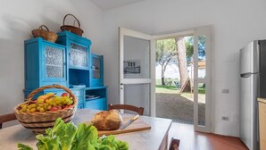 Een keuken met een gedekte tafel, een fruitmand en een brood.