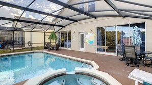 A covered outdoor swimming pool with a hot tub, patio furniture, and a mural on the wall. - Triton Vacation Pool Home Near Disney (Clermont)