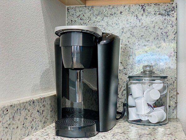 A coffee maker and a glass jar with white lids on a kitchen counter. - Pudge Vacation Pool SPA Home Near Disney (Clermont)