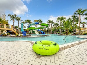 A swimming pool area with a water slide and a green inflatable ball labeled 'Windsor Island Resort'.