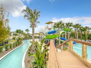 A water park with multiple slides, a pool, and a wooden deck.