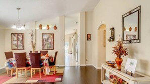 A spacious dining area with a long table, chairs, and a chandelier. - Flounder Vacation Home (Clermont)