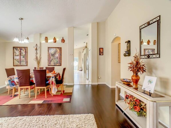 A spacious dining area with a long table, chairs, and a chandelier. - Flounder Vacation Home (Clermont)