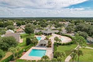 A residential area with a large swimming pool, multiple houses, and a gazebo. - Flounder Vacation Home (Clermont)