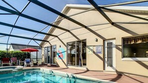 A swimming pool area with a glass ceiling, poolside chairs, and a red umbrella. - Sebastian Pool Villa W Spa (Clermont)