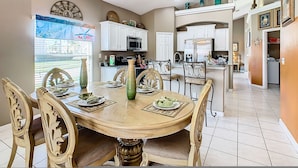 A dining area with a round table, chairs, and a view of the outside. - Sebastian Pool Villa W Spa (Clermont)