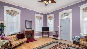 Un salon avec un canapé, une table basse, un téléviseur et une cheminée.