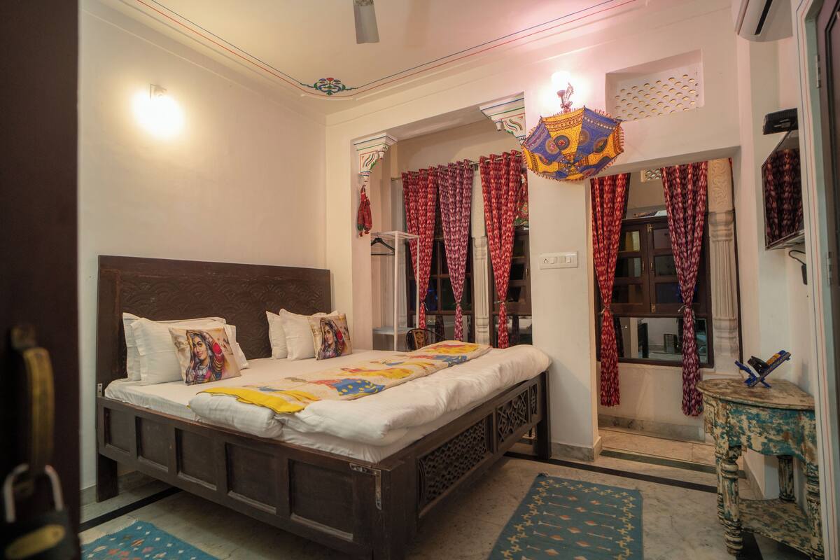 A bedroom with a wooden bed, patterned curtains, and a decorative ceiling light.