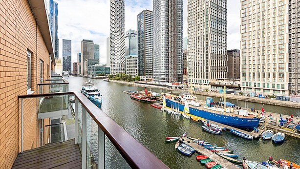 A river with boats docked, surrounded by high-rise buildings. - Bright and Stylish Riverside Haven in Canary Wharf (London)