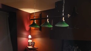 A pool table with balls, a lamp, and a vase of flowers. - l Aurigast (Auriac-Lagast)
