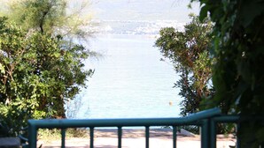 Une vue d’un lac, avec une rive lointaine, entouré d’arbres et agrémenté d’une balustrade au premier plan.