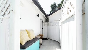A narrow outdoor patio with a white fence, a bench with cushions, and a potted plant. - 'The Sweet Pad' - Cozy Studio with WiFi and AC in lovely Ojai (Ojai)